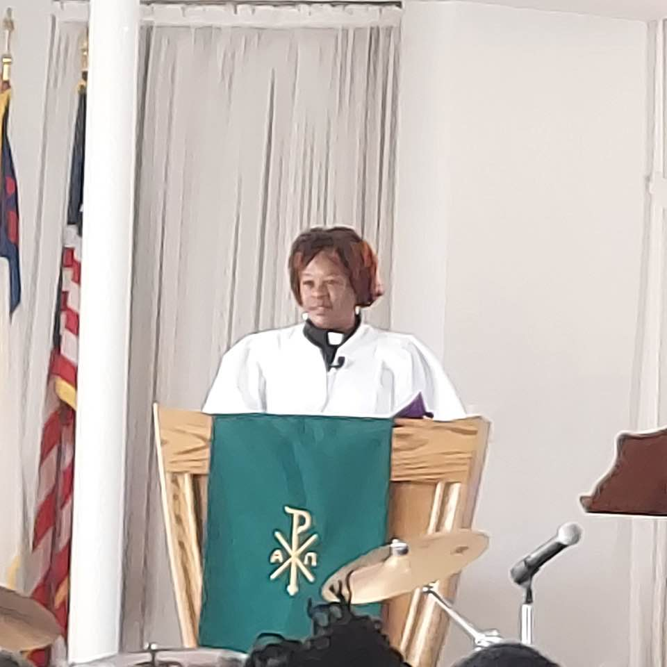 A woman is standing at a podium giving a speech in a church.