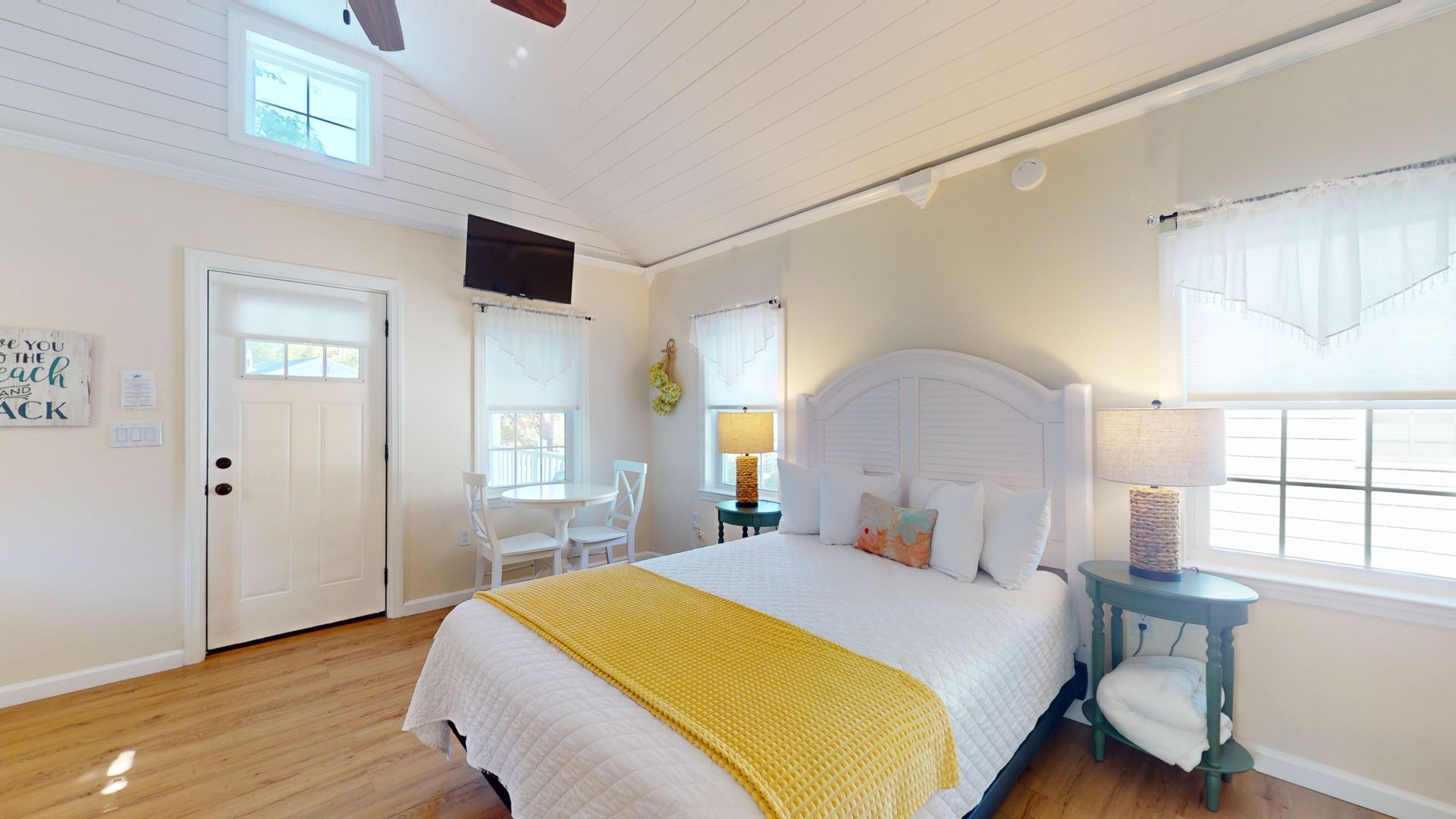 A bedroom with a king size bed , a nightstand , a table and a television.