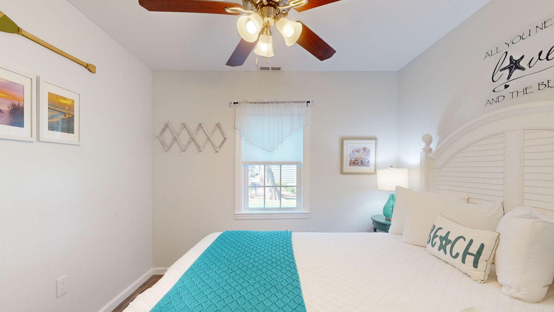 A bedroom with a bed and a ceiling fan.