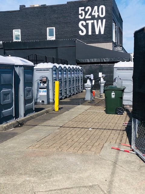 A row of portable toilets in front of a building that says 5240 stw