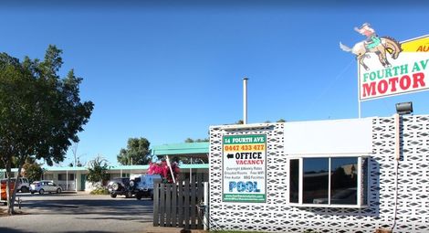 Fourth Avenue Motor motel with a sign featuring a cowboy riding a donkey; exterior shot.