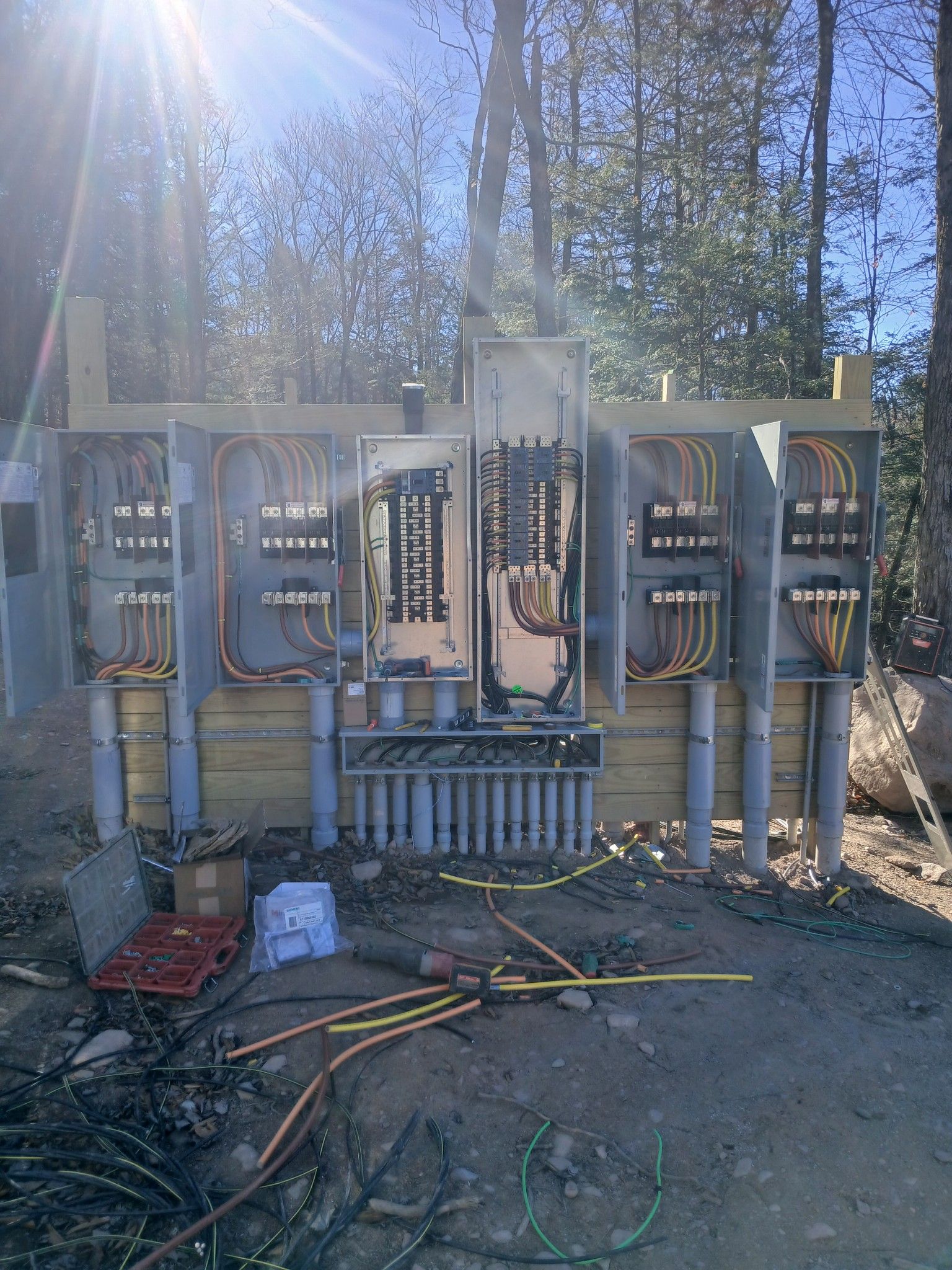American Electric LLC | A large electrical box is sitting in the middle of a dirt field.