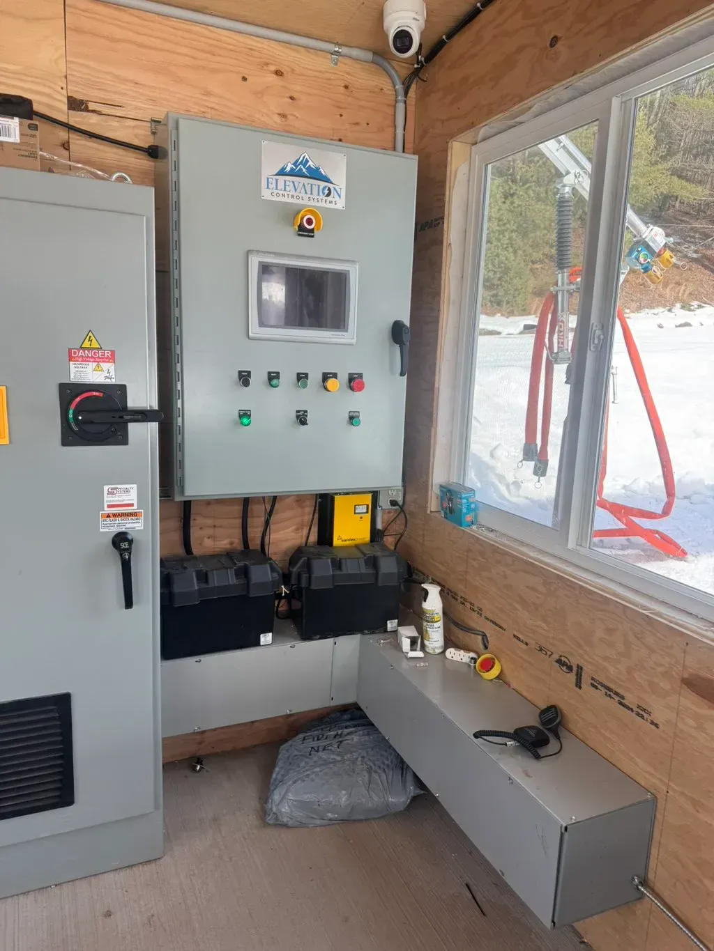 American Electric LLC | A room with a lot of electrical equipment and a window.