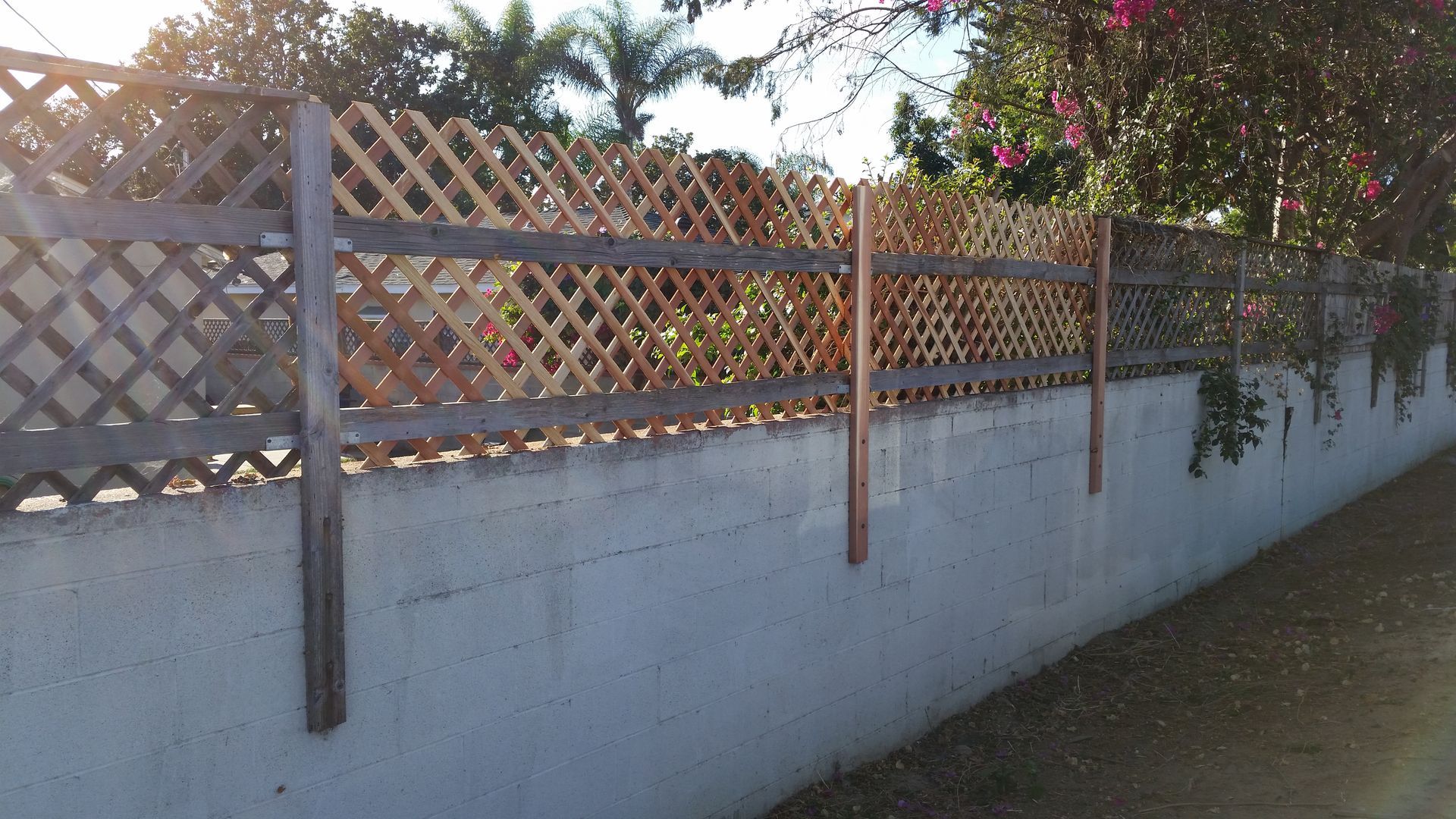 A white wall with a wooden fence on it