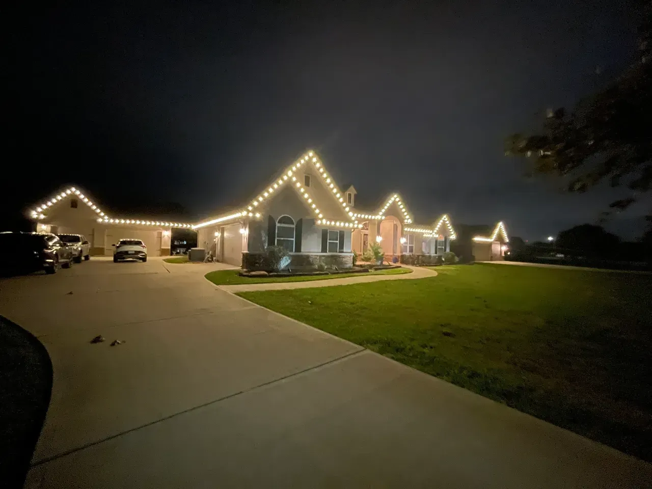 A house with christmas lights on it is lit up at night.