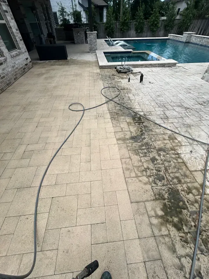 A patio with a hose attached to it and a pool in the background.