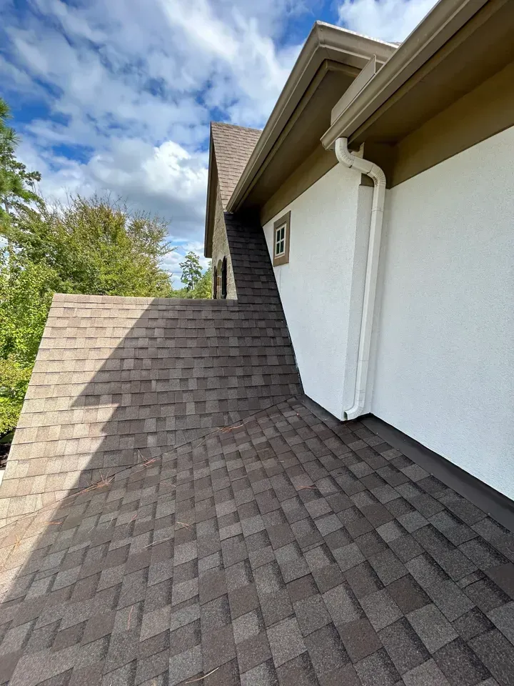 A house with a brown roof and a white wall.