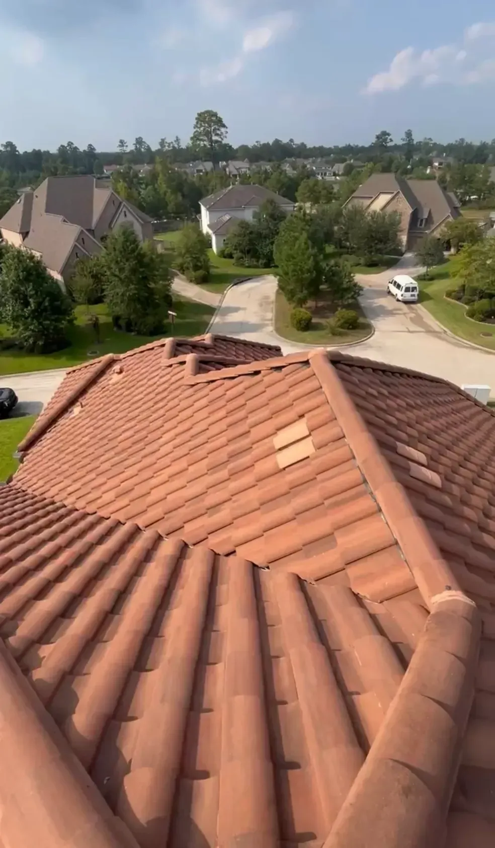 A view of a roof from the top of a house in a residential area.