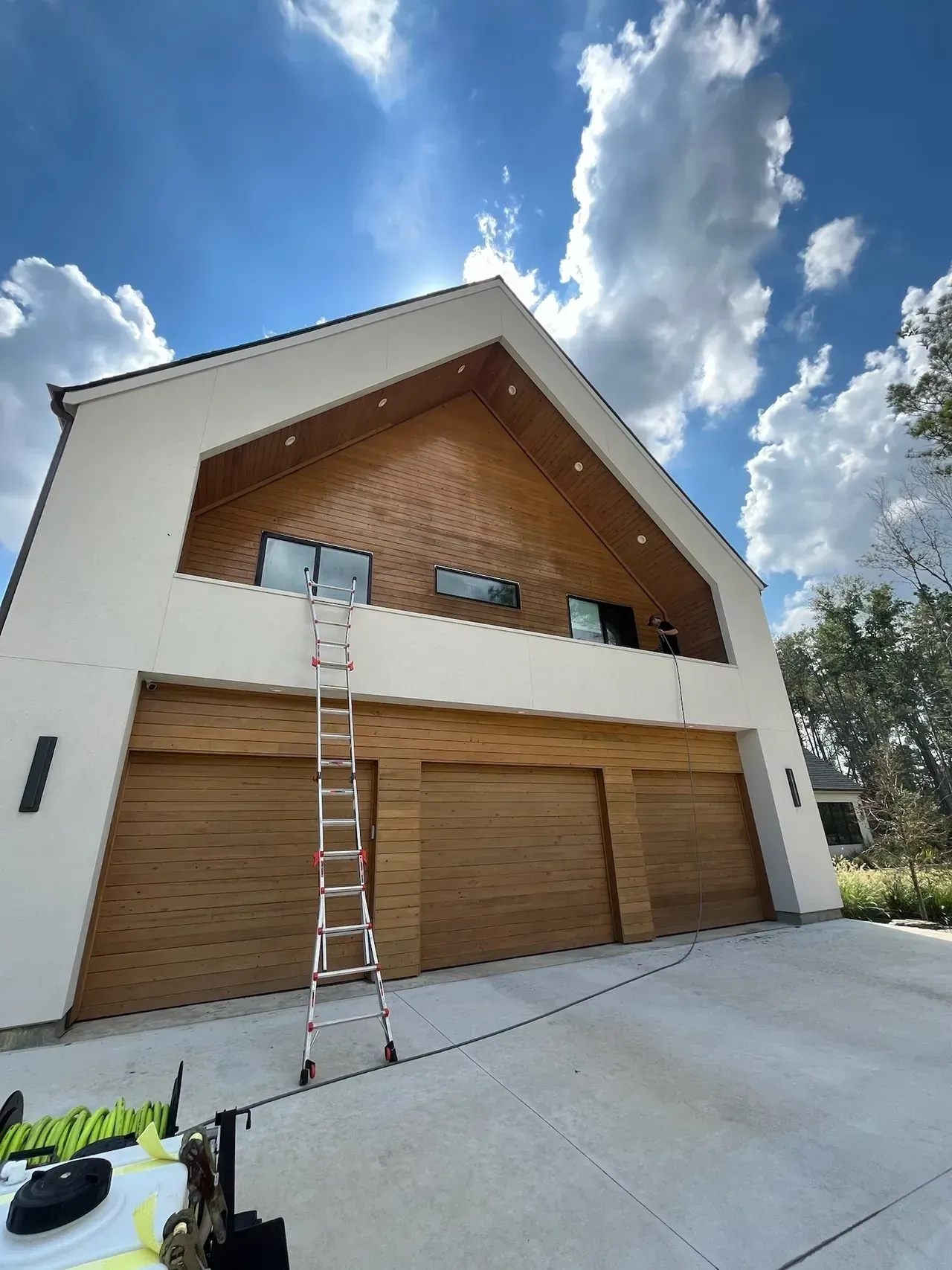 A ladder is sitting in front of a large house.