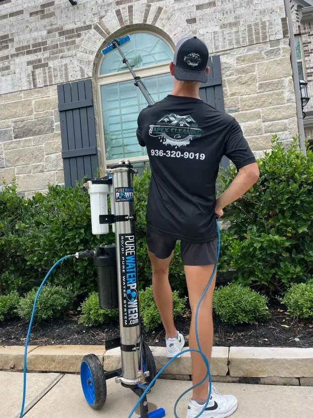 A man is cleaning a window with a machine.