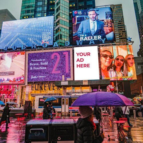 A woman holding a purple umbrella in front of a billboard that says your ad here