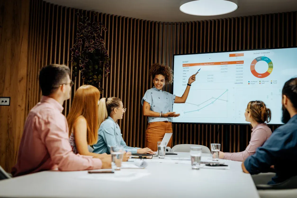 Two women are sitting on a couch looking at a cell phone