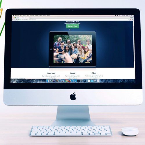 An apple computer with a picture of a group of people on the screen