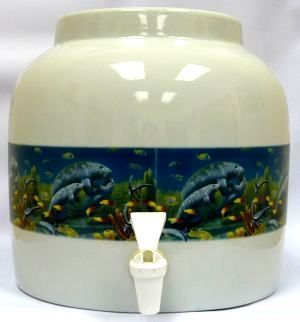 Ceramic water dispenser with manatee design. Off-white with blue band depicting manatees underwater; white spout.