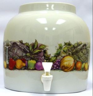Cream-colored ceramic beverage dispenser with fruit pattern and a white spout.