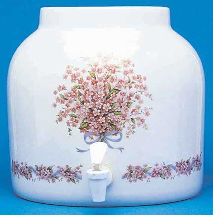 White ceramic water dispenser with pink floral design and spigot.