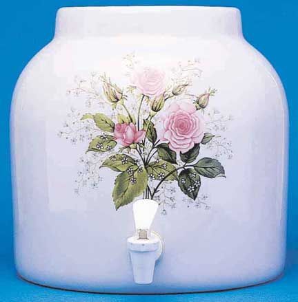White ceramic water dispenser with pink rose floral design and spigot.