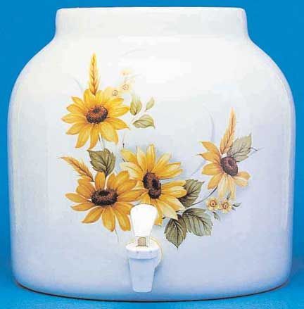White ceramic water dispenser with sunflower design and a spigot.