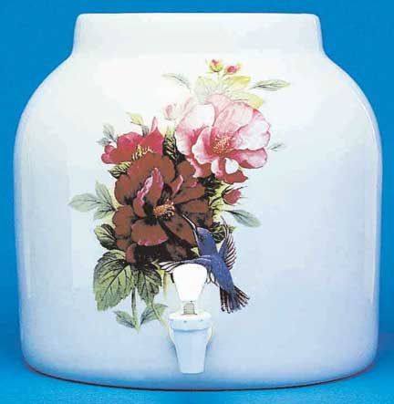 White ceramic water dispenser with floral and hummingbird design; has a white spigot.