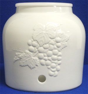 White ceramic water dispenser with cherub painting and white spigot.