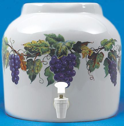 White ceramic water dispenser with grape vine design and a spigot.