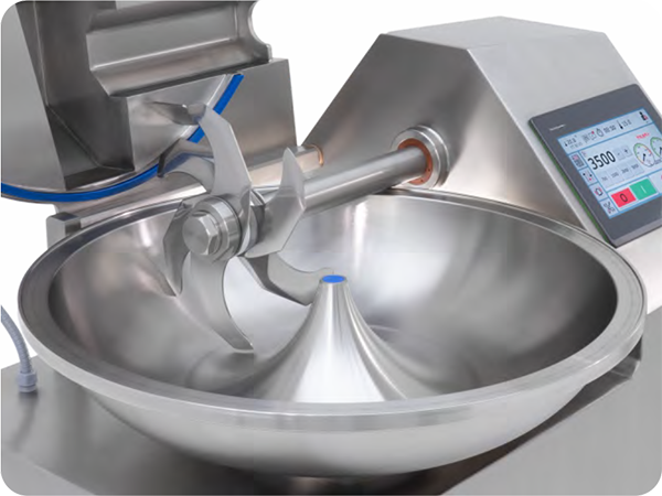 A stainless steel bowl is sitting on top of a machine.