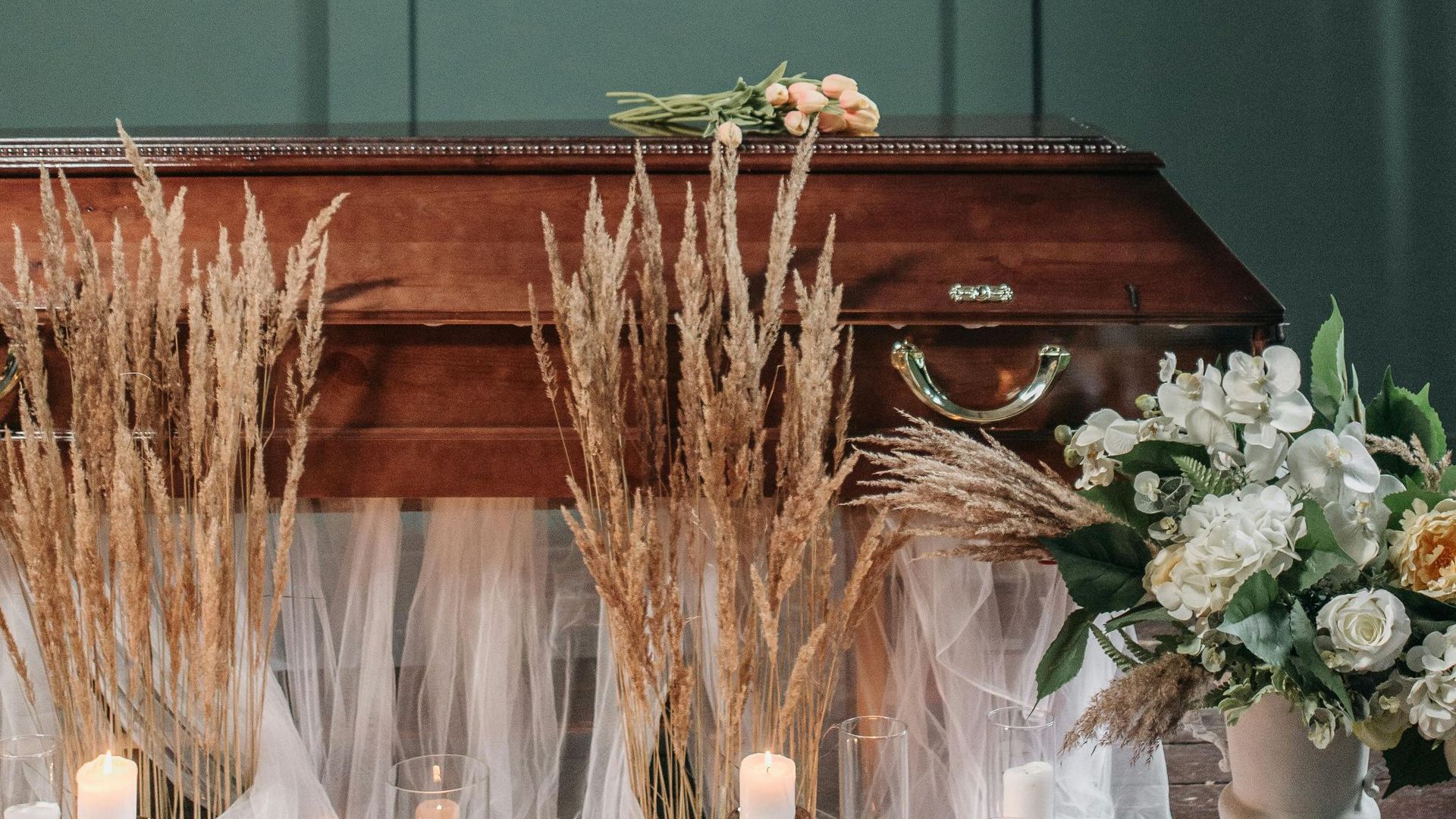 a man in a suit holds a white rose in front of candles