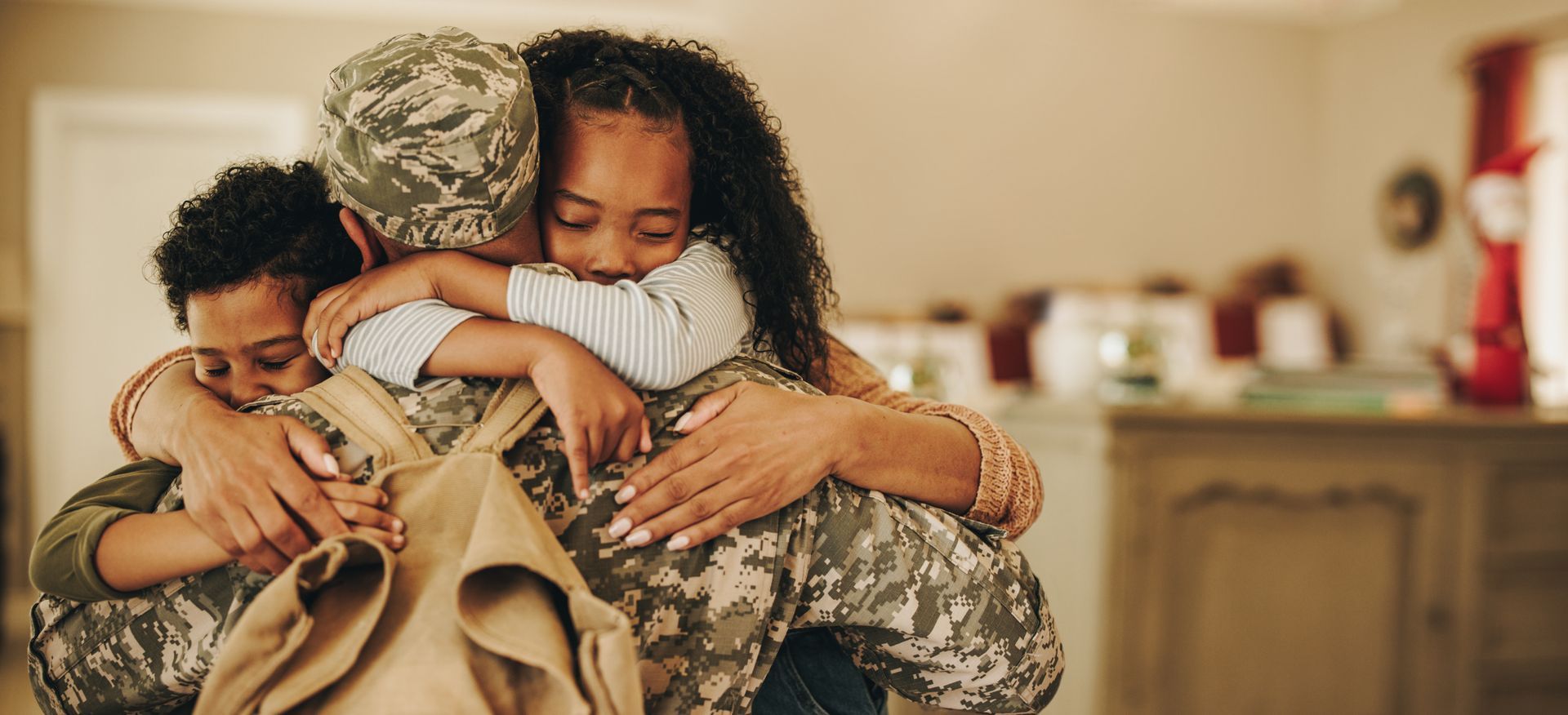 a little girl hugging a soldier with an american flag on his back