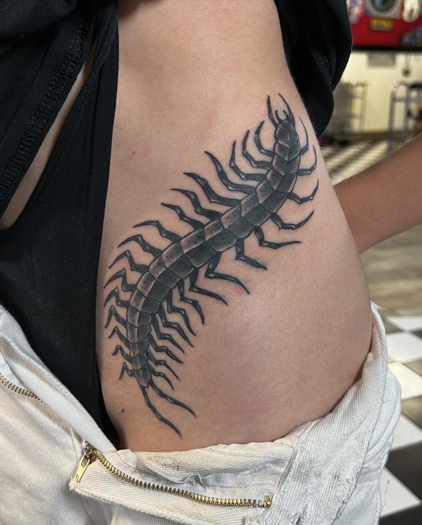 A person has a tattoo of a centipede on their side