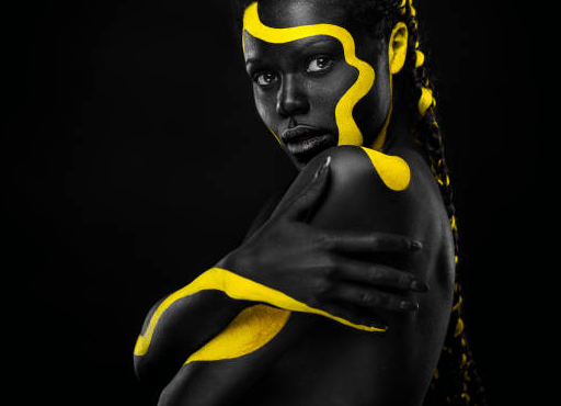 A woman with black and yellow paint on her face and body.