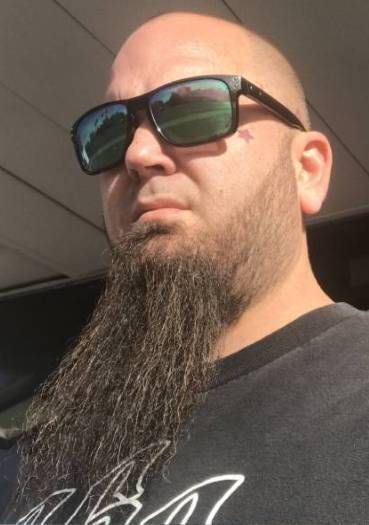 A bald man with a long beard wearing sunglasses