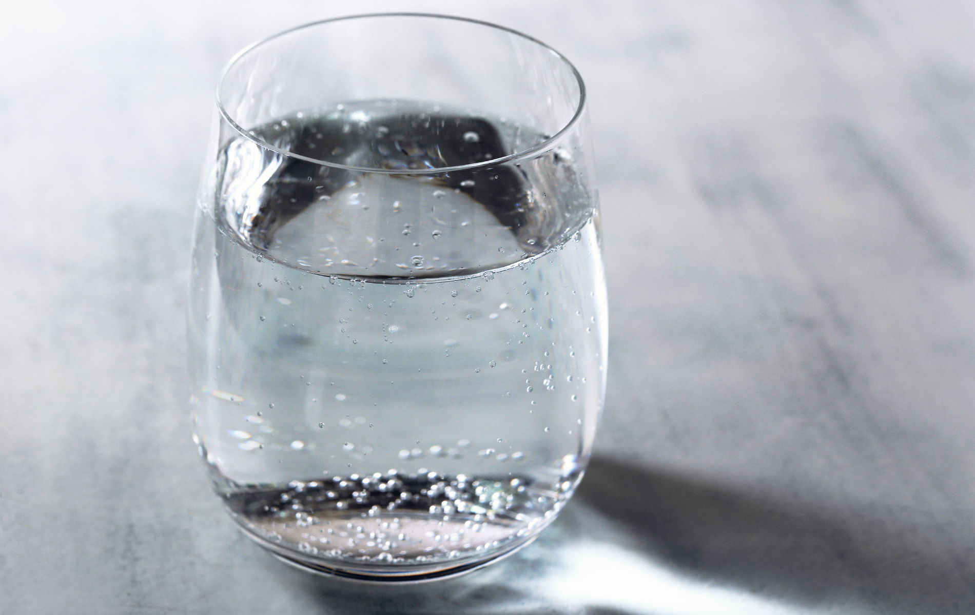 A glass of water is sitting on a table.
