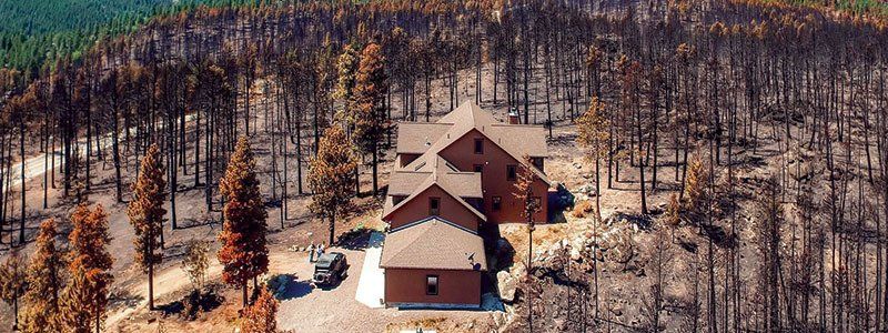 An aerial view of a house in the middle of a forest