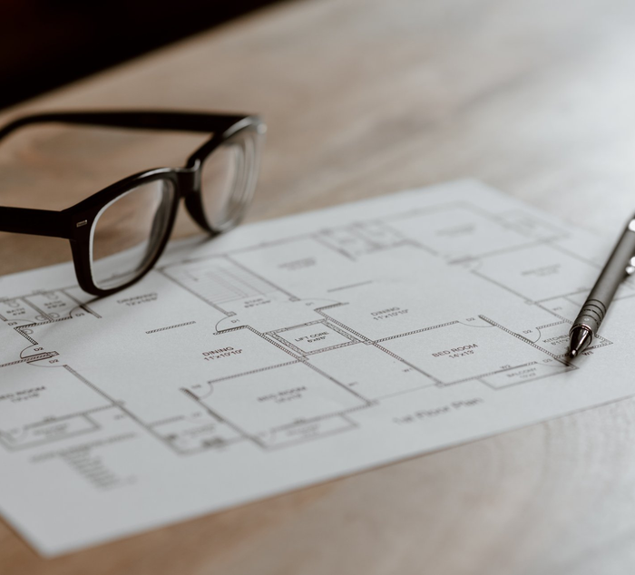 A pair of glasses sits on top of a floor plan