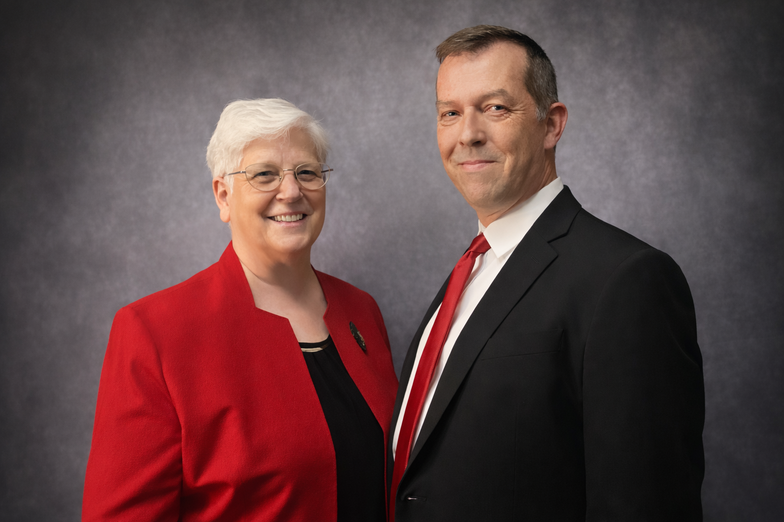 a large house is sitting on the shore of a lake surrounded by trees .