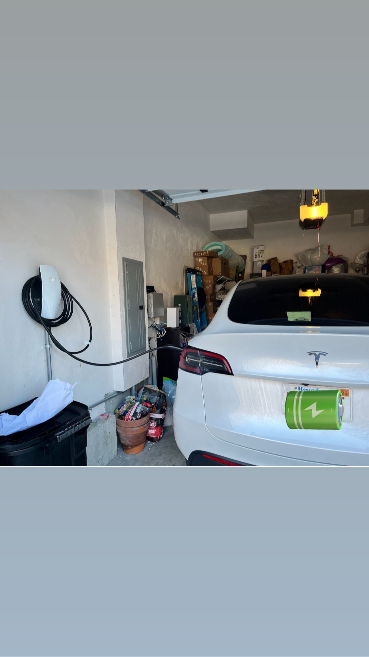 A white tesla model s is charging in a garage.