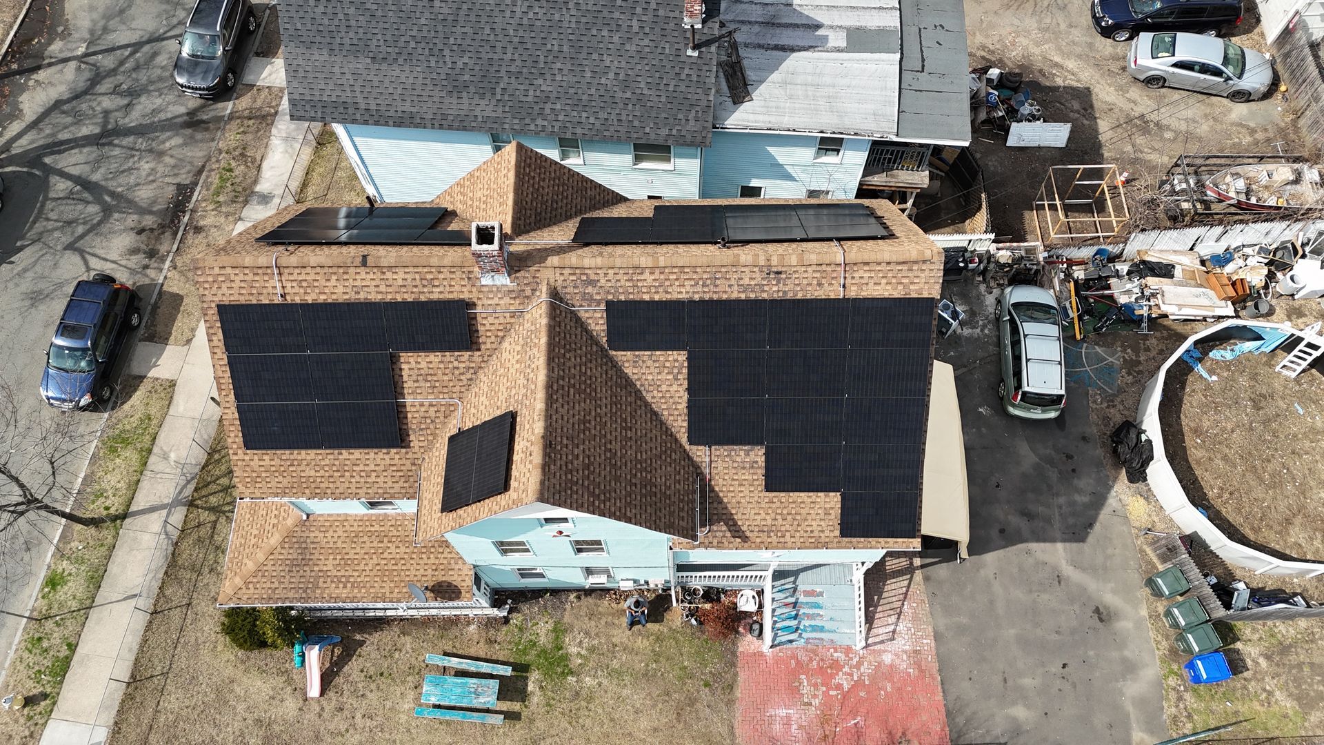 An aerial view of a house with solar panels on the roof.