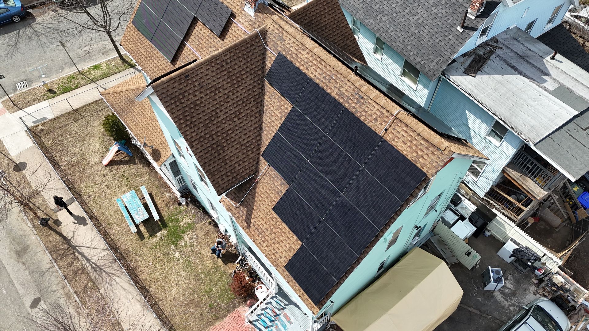 An aerial view of a house with solar panels on the roof.