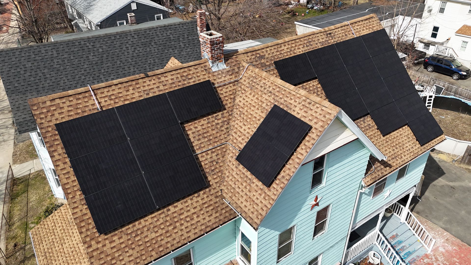 An aerial view of a house with solar panels on the roof