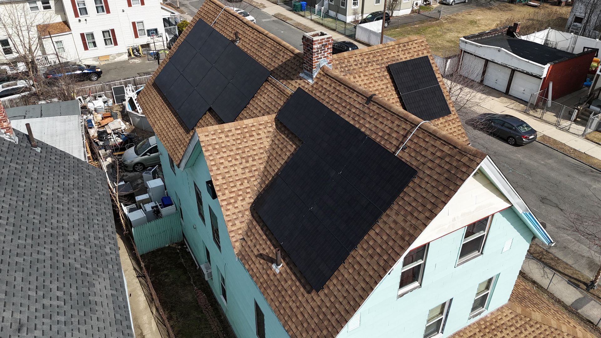 An aerial view of a house with solar panels on the roof.