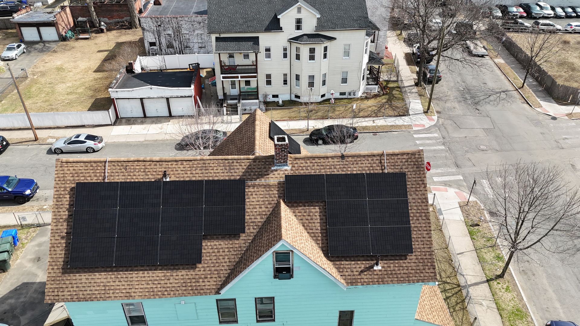 An aerial view of a house with solar panels on the roof.