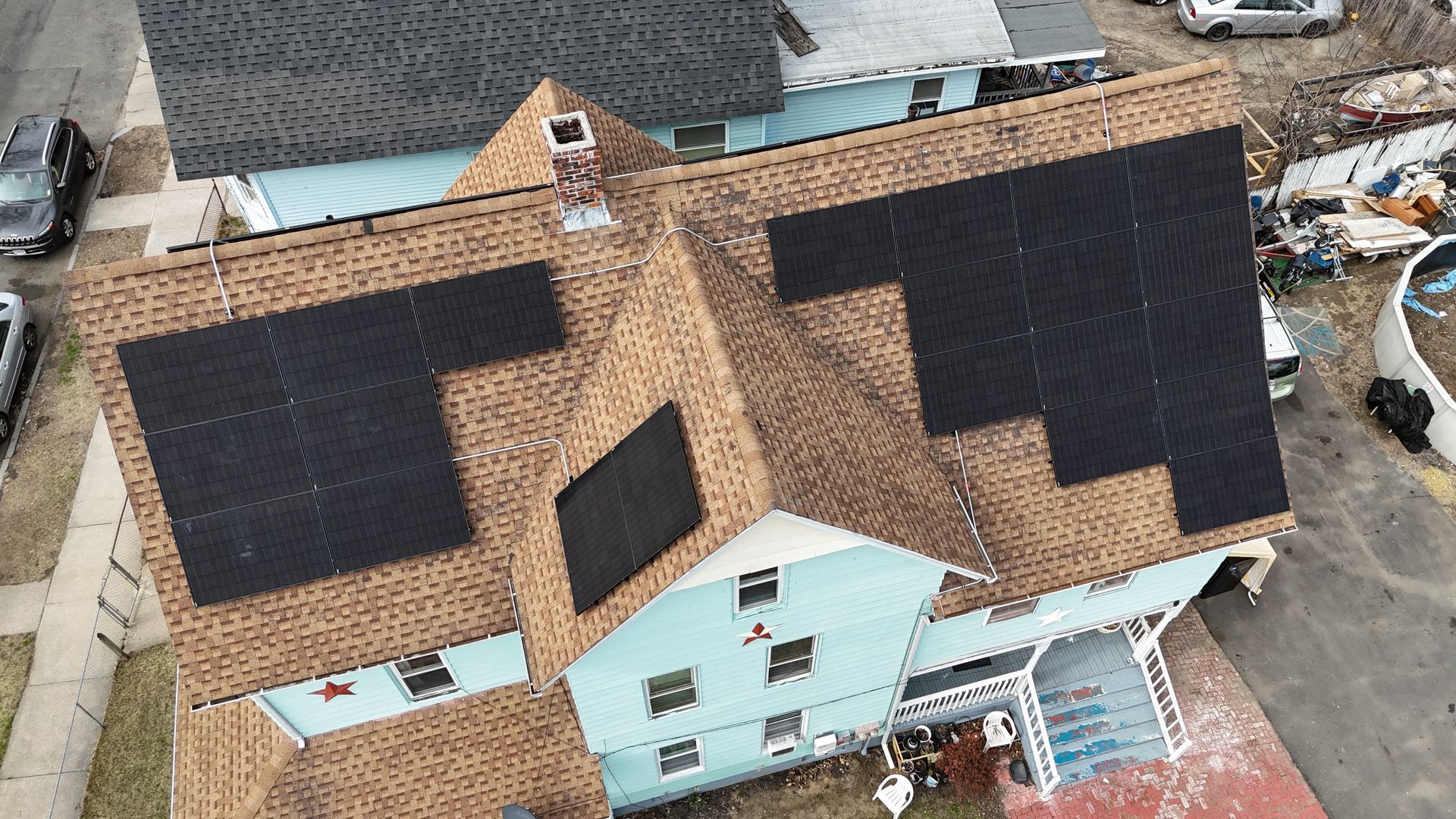 An aerial view of a house with solar panels on the roof
