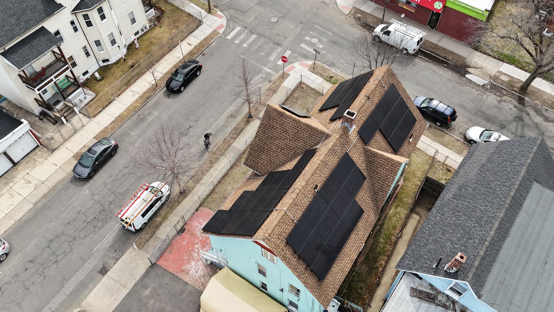 An aerial view of a house with solar panels on the roof.