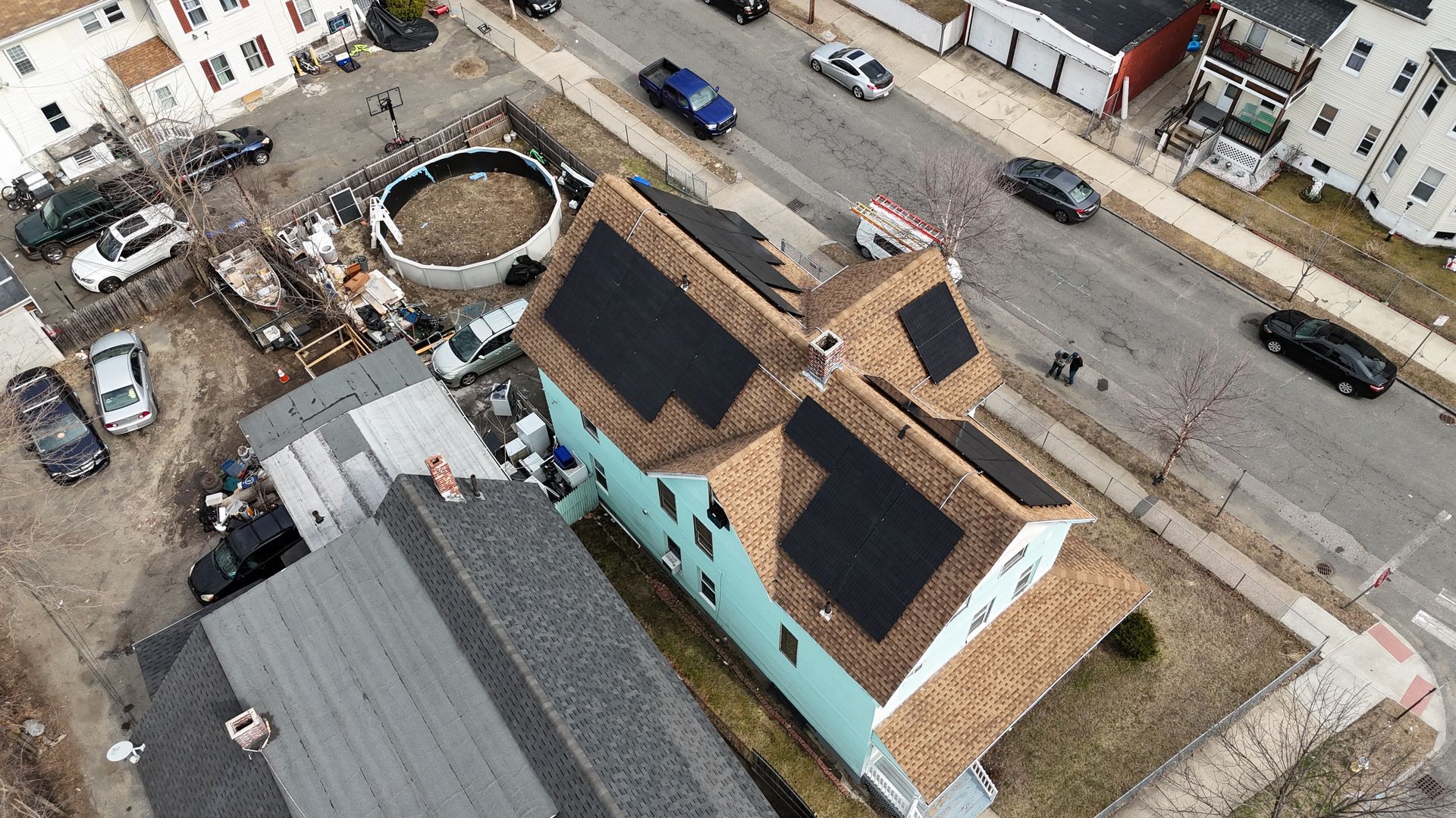 An aerial view of a house with solar panels on the roof.