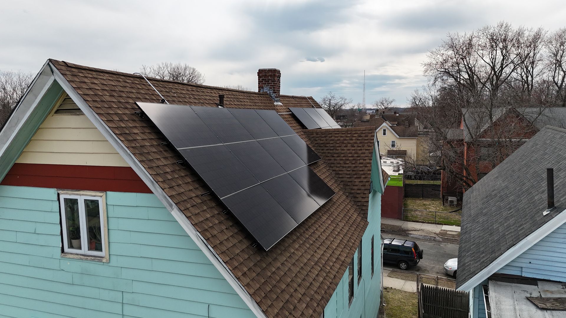 A blue house with solar panels on the roof