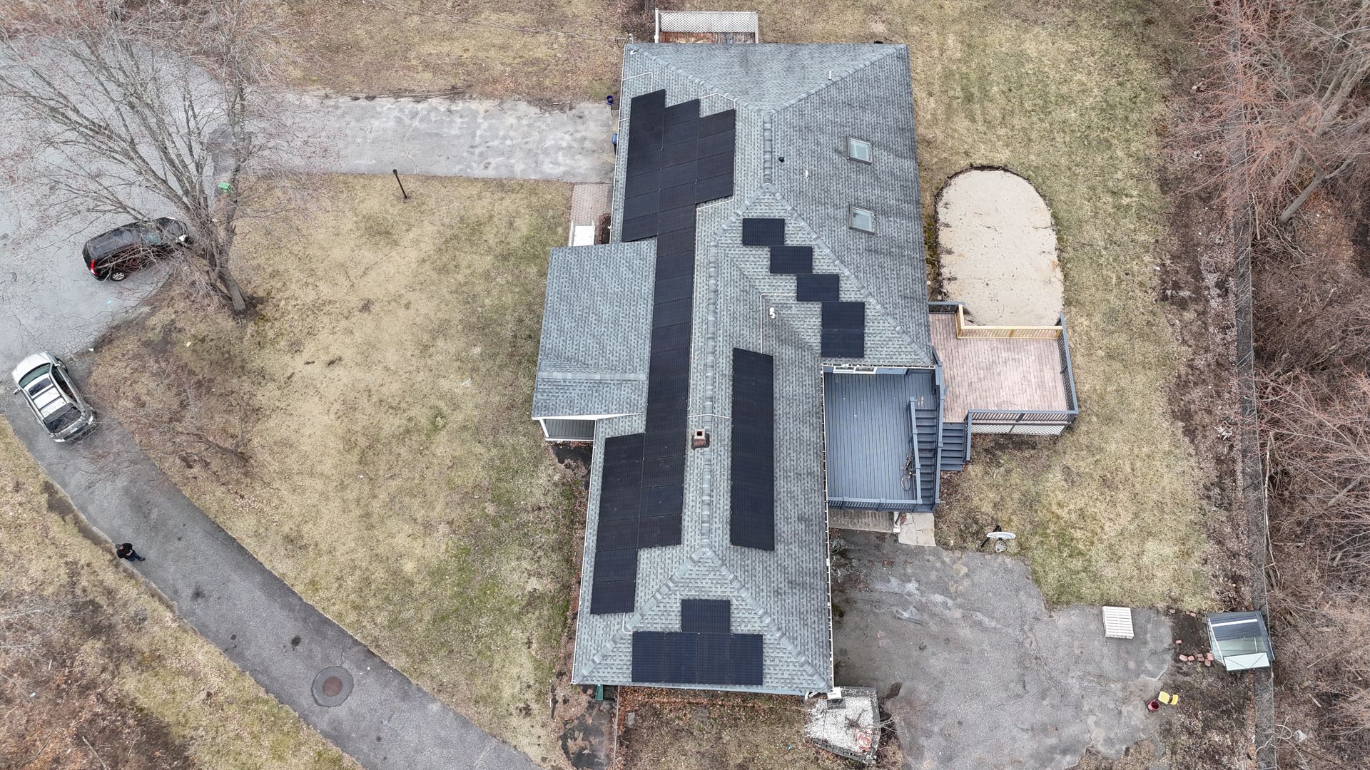 An aerial view of a house with a solar panel on the roof.