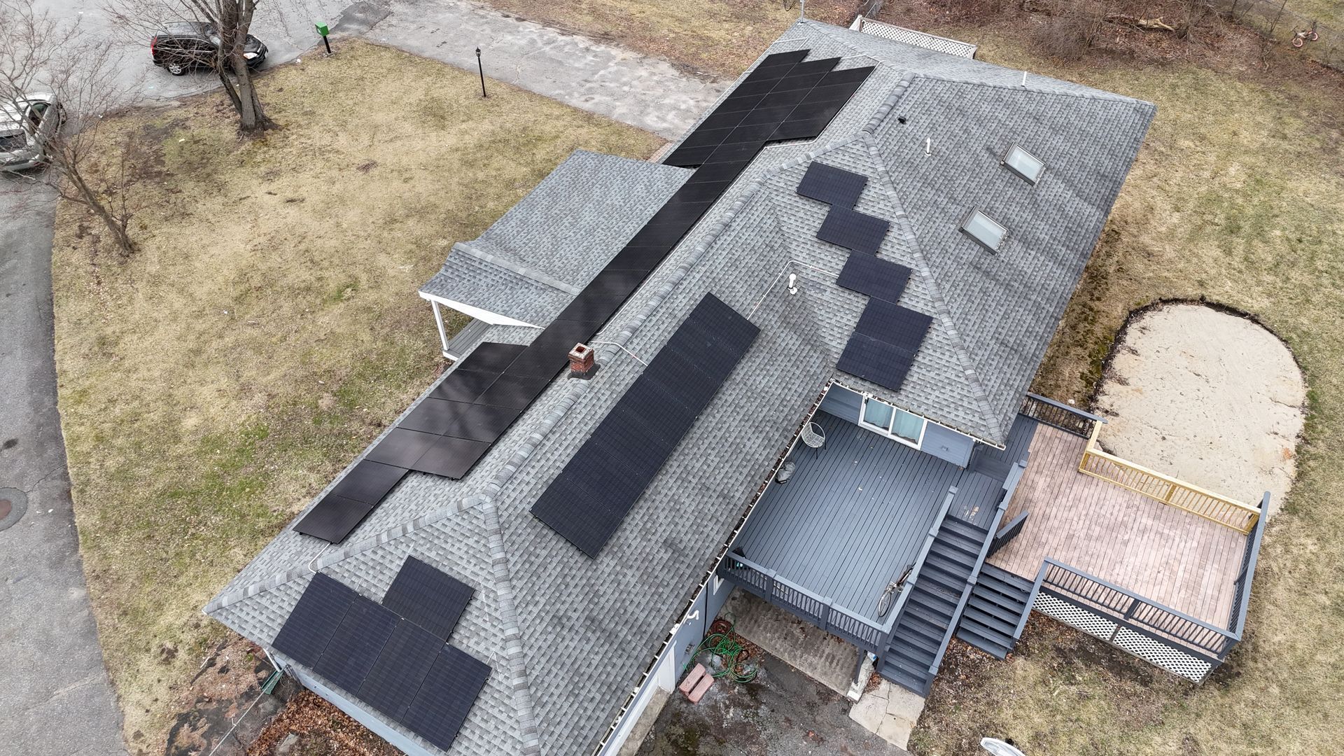 An aerial view of a house with solar panels on the roof.