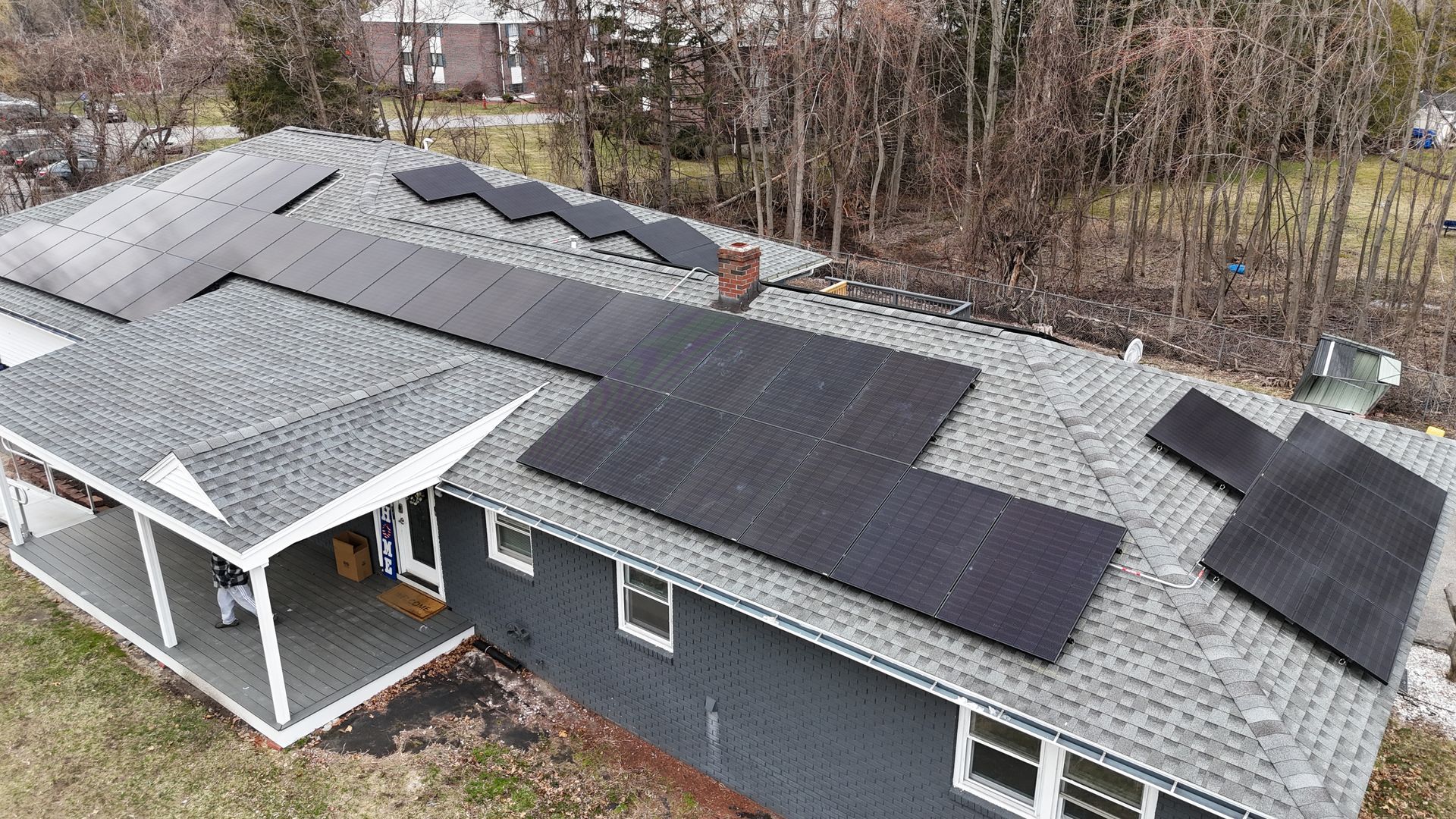 An aerial view of a house with solar panels on the roof.