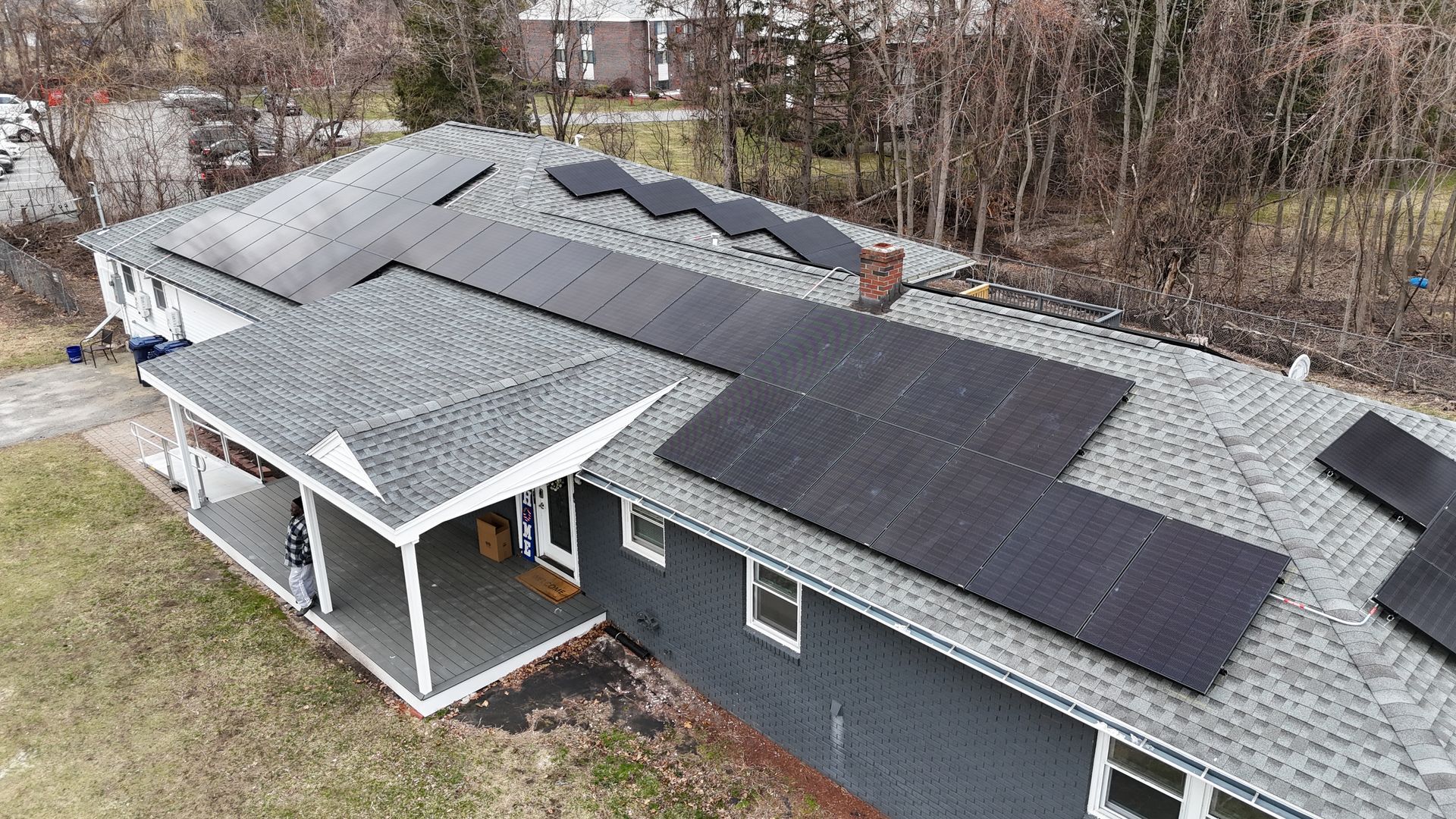 An aerial view of a house with solar panels on the roof.