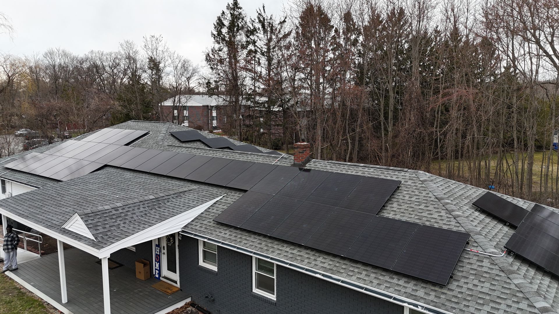 An aerial view of a house with solar panels on the roof.